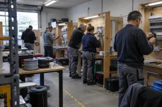 Adultes en formation d’électricien câblant des tableaux d’exercice dans l’atelier d’un centre de formation